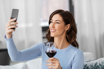 Image showing woman with smartphone and wine taking selfie