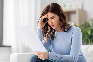 Image showing stressed woman with paper sheet at home