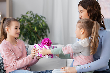 Image showing girl giving present to younger sister at home