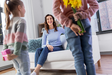 Image showing daughters giving flowers and gift to happy mother