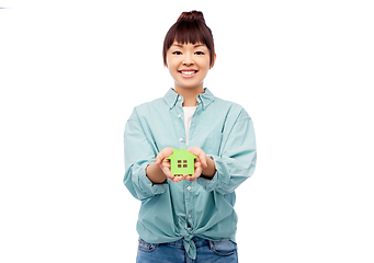 Image showing smiling asian woman holding green house