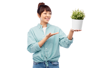 Image showing happy smiling asian woman holding flower in pot
