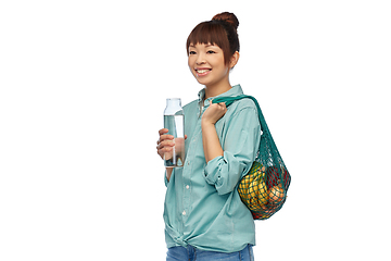 Image showing woman with food in string bag and glass bottle