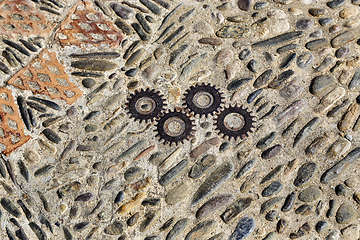 Image showing Unusual floor with pattern from pebbles, brick and rusty metal d