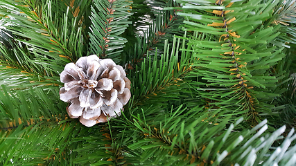 Image showing Bright green branches of an artificial Christmas tree with a con