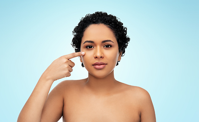 Image showing young african american woman pointing to her face