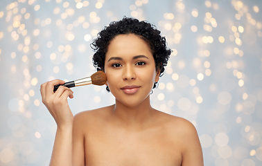 Image showing woman with make up brush applying blush to face