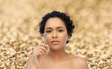 Image showing african american woman with eyelash curler