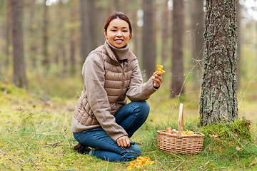 Image showing asian woman with thermos drinking tea in forest