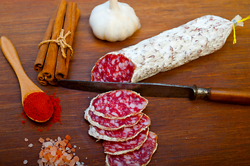 Image showing traditional Italian salame cured sausage sliced on a wood board