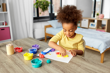 Image showing little girl with modeling clay playing at home