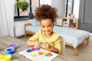 Image showing little girl with modeling clay playing at home