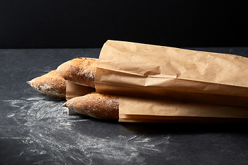 Image showing close up of baguette bread in paper bags on table