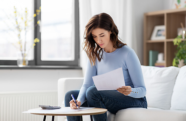 Image showing woman with papers and calculator at home