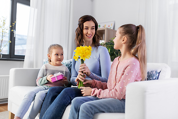 Image showing daughters giving flowers and gift to happy mother