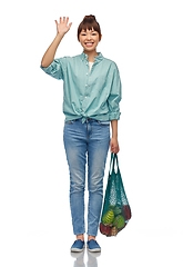 Image showing happy asian woman with food in reusable string bag