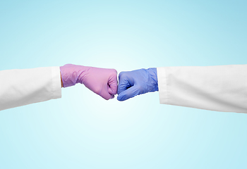 Image showing hands of doctors in gloves make fist bump gesture