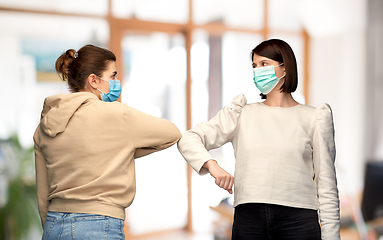 Image showing women in masks making elbow bump greeting gesture