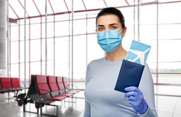 Image showing young woman in mask with air ticket and passport