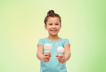 Image showing smiling girl comparing different light bulbs