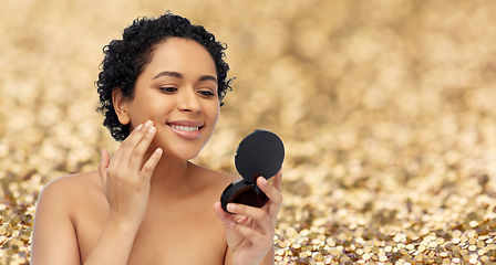 Image showing smiling african american woman looking to mirror