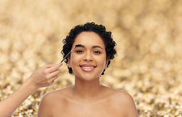 Image showing happy woman and hand of make up artist with brush