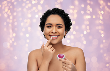 Image showing african american woman applying lip gloss