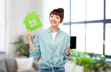 Image showing smiling asian woman holding green house