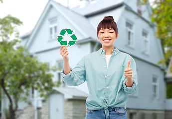 Image showing smiling asian woman holding green recycling sign