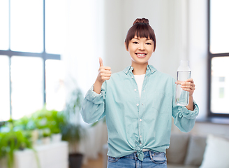 Image showing happy asian woman holding glass bottle with water