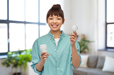 Image showing asian woman holding energy saving lighting bulb