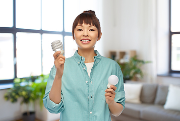 Image showing asian woman holding energy saving lighting bulb