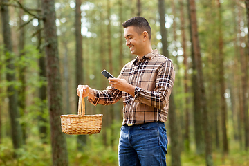 Image showing man using smartphone to identify mushroom