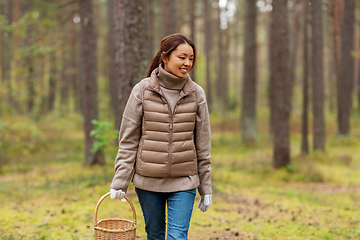 Image showing young woman picking mushrooms in autumn forest