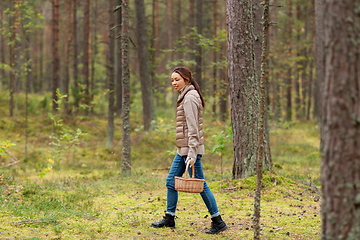 Image showing young woman picking mushrooms in autumn forest