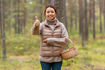 Image showing woman with mushrooms showing thumbs up in forest