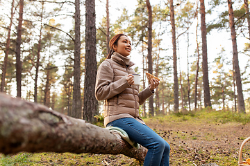 Image showing woman with mushrooms drinks tea and eats in forest