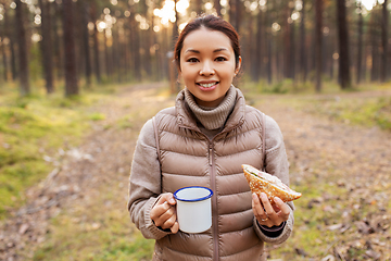 Image showing woman with mushrooms drinks tea and eats in forest