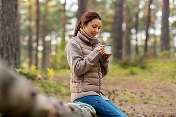 Image showing asian woman with mug drinking tea in forest