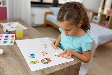 Image showing little girl painting wooden items at home