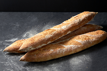 Image showing baguette bread on table over dark background