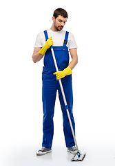 Image showing male cleaner in overal cleaning floor with mop