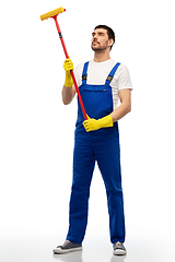 Image showing male cleaner in overal with window cleaning mop