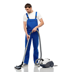 Image showing male worker cleaning floor with vacuum cleaner