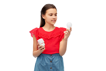 Image showing smiling girl comparing different light bulbs