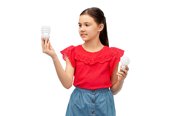 Image showing smiling girl comparing different light bulbs