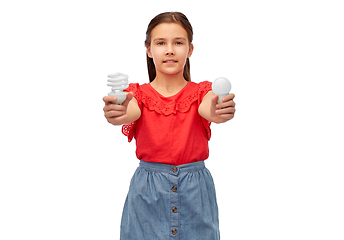Image showing smiling girl comparing different light bulbs