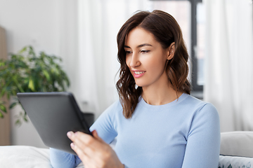 Image showing happy smiling young woman with tablet pc at home