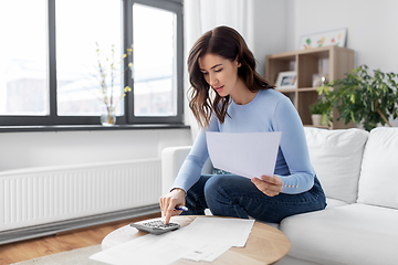 Image showing woman with papers and calculator at home