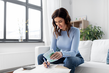 Image showing happy woman counting money at home